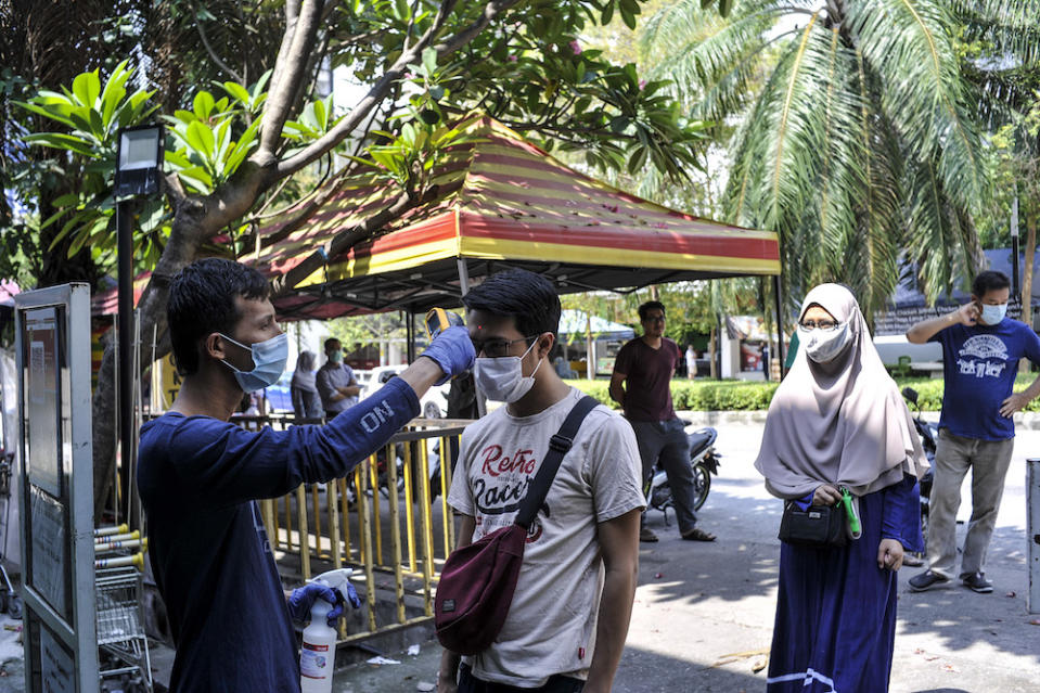 Members of the public have their temperature checked at the Baba Dona Super Mart in Lembah Pantai, Kuala Lumpur March 22, 2020. — Picture by Shafwan Zaidon