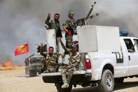 Iraq's Shi'ite paramilitaries ride in military vehicles in Nibai May 26, 2015. REUTERS/Stringer