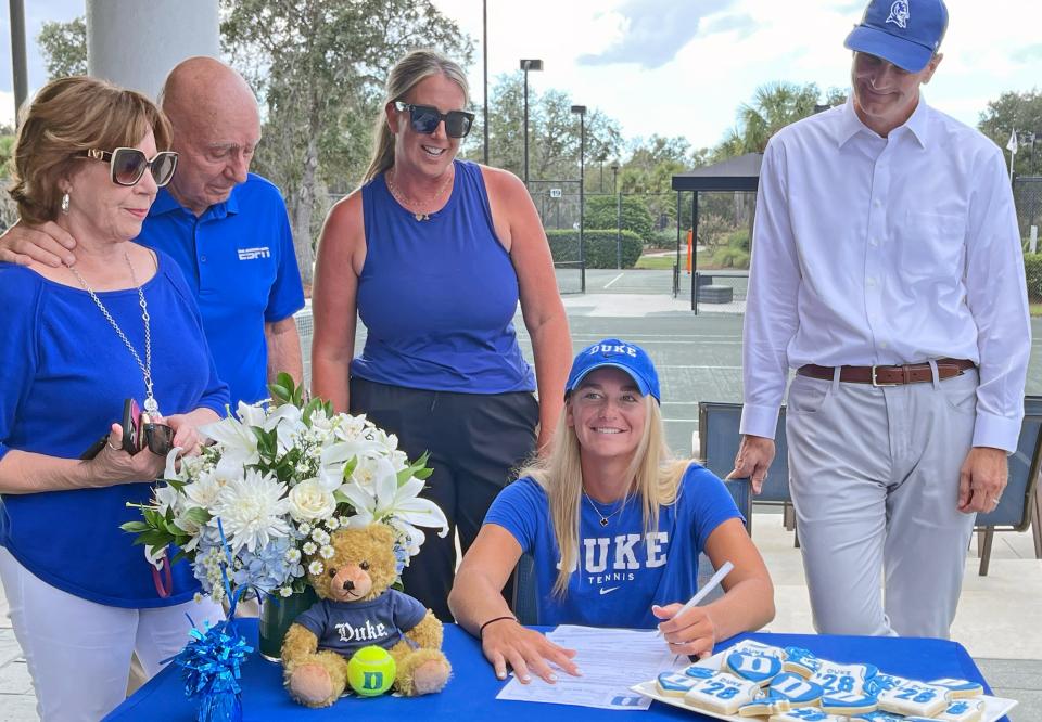 Ava Krug smiles just before signing her national letter of intent to join the Blue Devil women's team at Duke University. Surrounded by her family, Lorraine McGrath Vitale, ESPN college basketball analyst Dick Vitale, Ava's mom Sherri and dad former Notre Dame quarterback, Thomas Krug at the Lakewood Ranch Golf & Country Club, where Krug's, 18, formative tennis years were spent. THOMAS BENDER/HERALD-TRIBUNE