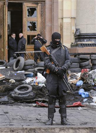 An armed man, representing Ukrainian special forces, stands guard outside the regional administration building in Kharkiv, April 8, 2014. REUTERS/Olga Ivashchenko