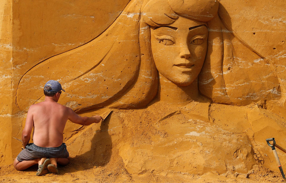 <p>An artist works on a sculpture during the Sand Sculpture Festival “Disney Sand Magic” in Ostend, Belgium June 22, 2017. (Yves Herman/Reuters) </p>