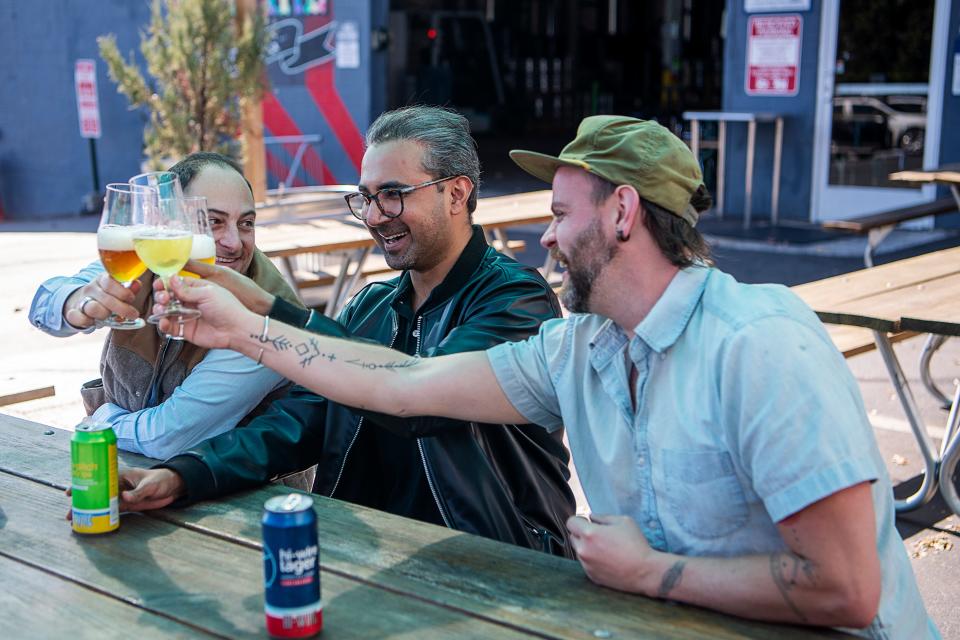 From left, Adam Charnack, co-owner of Hi-Wire Brewing, Ali Amin, co-founder of Rebel Burger, and Christian Albrecht, co-founder and chef of Rebel Burger, at Hi-Wire, November 8, 2023.