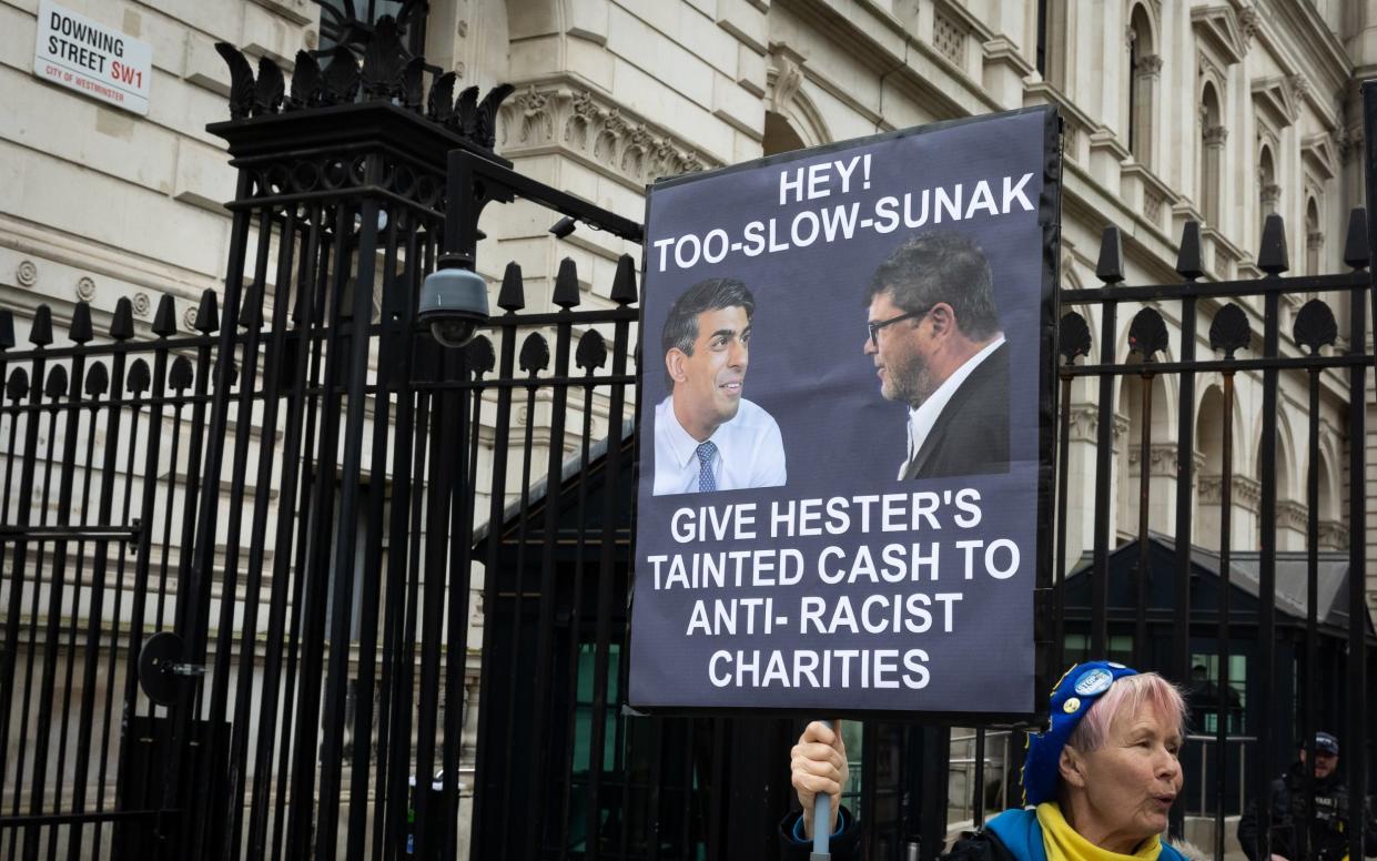 Protestor holds up placard outside Downing Street calling for Government to give back Frank Hester's donations