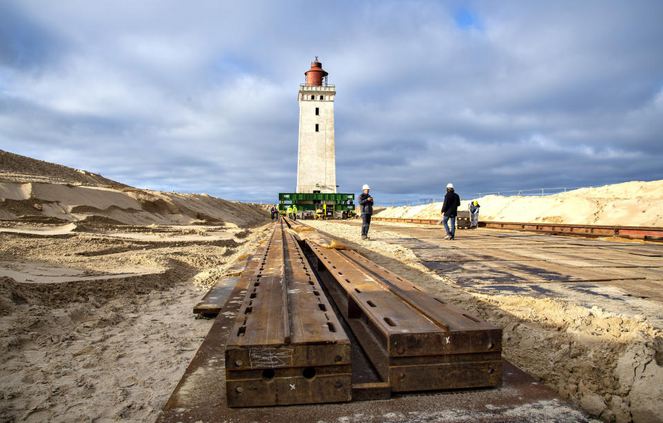 In this photo taken on Monday, Oct. 21, 2019, preparations are being made to move the Rubjerg Knude Lighthouse in Jutland, Denmark. A 120-year-old lighthouse has been put on wheels and rails to attempt to move it some 80 meters (263 feet) away from the North Sea, which has been eroding the coastline of northwestern Denmark. When the 23-meter (76 feet) tall Rubjerg Knude lighthouse was first lit, in 1990, it was roughly 200 meters (656 feet) from the coast; now it is only about 6 meters away. (Henning Bagger/Ritzau Scanpix via AP)