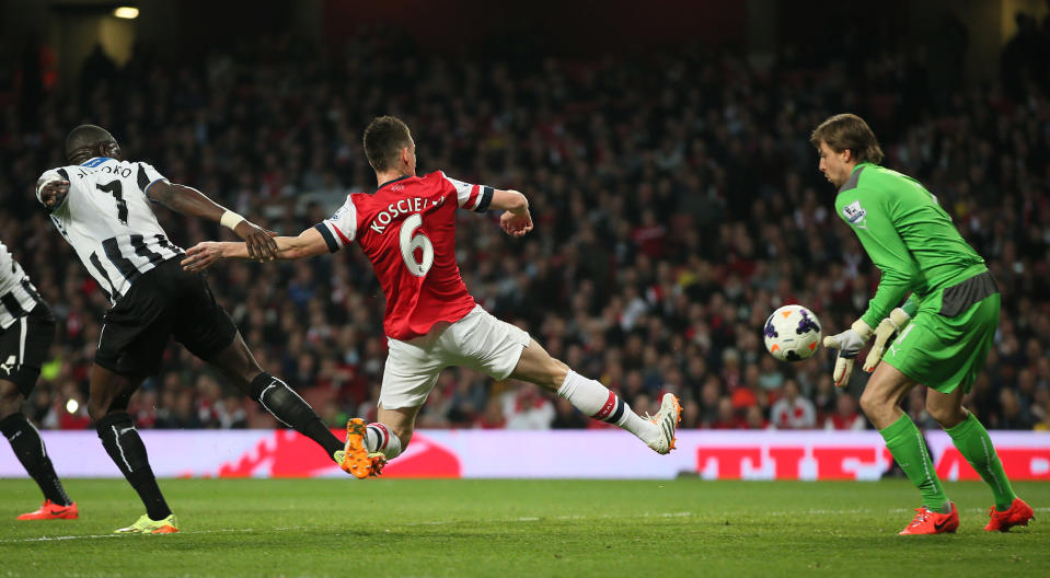 Arsenal's Laurent Koscielny, kicks the ball past Newcastle's goalkeeper Tim Krul to score the opening goal during, their English Premier League soccer match between Arsenal and Newcastle United at the Emirates stadium in London, Monday, April 28, 2014. (AP Photo/Alastair Grant)