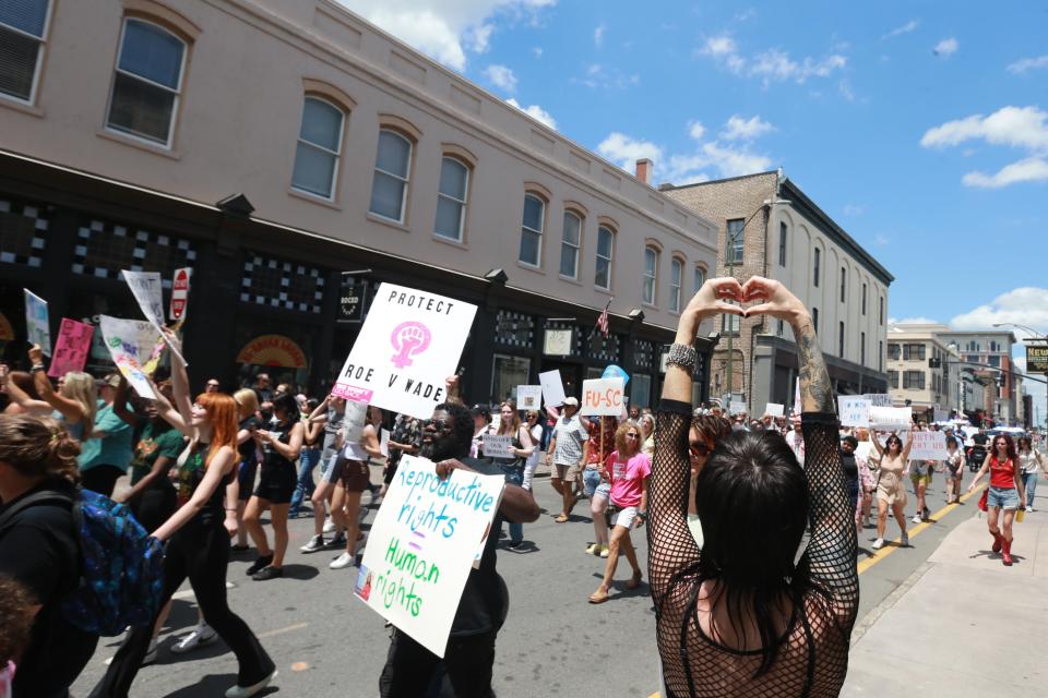 A woman holds her hands in the shape of a heart as abortion rights supporters march along Whitaker Street on Saturday May 14, 2022 in Savannah Georgia.