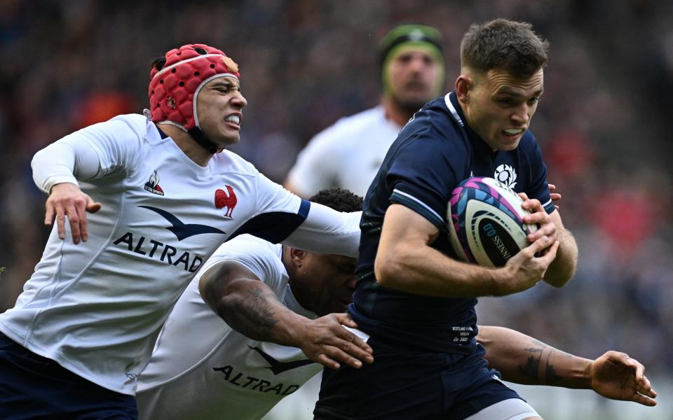 Scottish scrumhalf Ben White (R) runs towards the line being tackled by French wing Louis Bielle-Biarrey (L) and French center Jonathan Danty (C) ahead of the first try during the Six Nations international rugby match between Scotland and France at Murrayfield Stadium in Edinburgh, Scotland on February 10, 2024