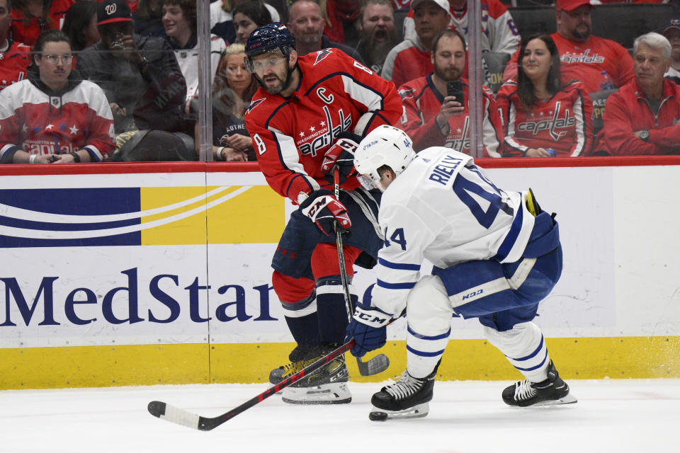 Washington Capitals left wing Alex Ovechkin (8) passes the puck against Toronto Maple Leafs defenseman Morgan Rielly (44) during the first period of an NHL hockey game, Sunday, April 24, 2022, in Washington. (AP Photo/Nick Wass)