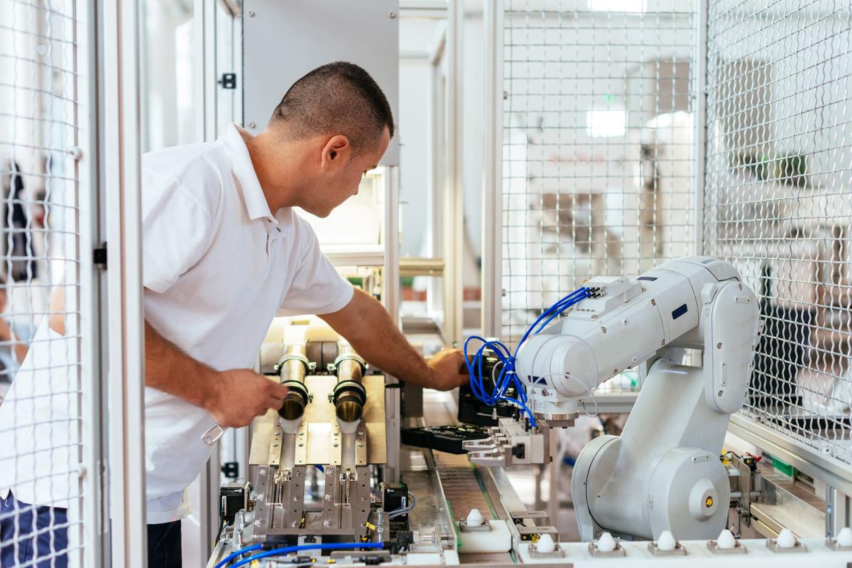 engineer is examining modern production line robot