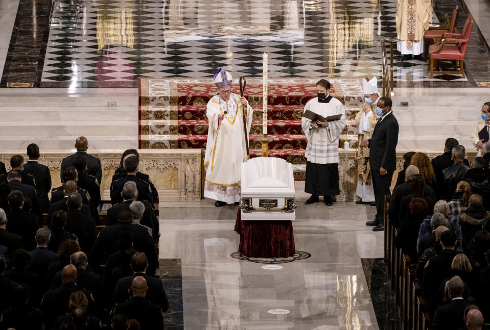 Cardinal Timothy Dolan sprinkles holy water on the casket holding slain NYPD officer Wilbert Mora during a funeral service at St. Patrick's Cathedral in New York Wednesday, Feb. 2, 2022. Mora was shot and killed after responding to a domestic dispute call on Jan. 21 with his partner Jason Rivera, who was also fatally wounded. (Craig Ruttle/Newsday via AP, Pool)