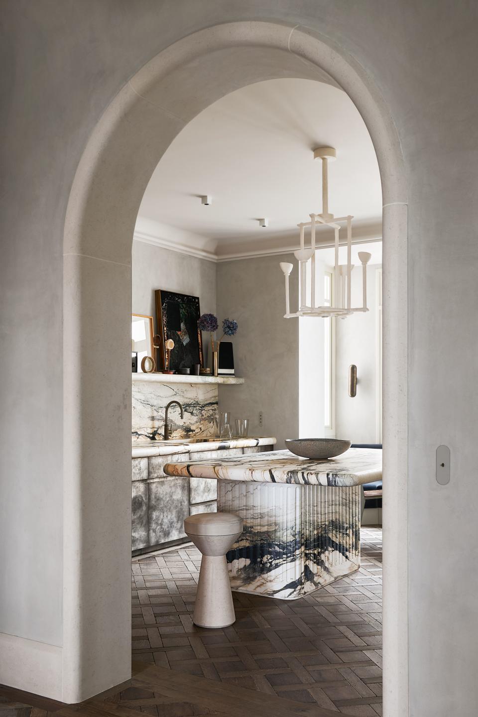 A Breccia Stazzema marble island anchors the kitchen. Philippe Anthonioz chandelier.