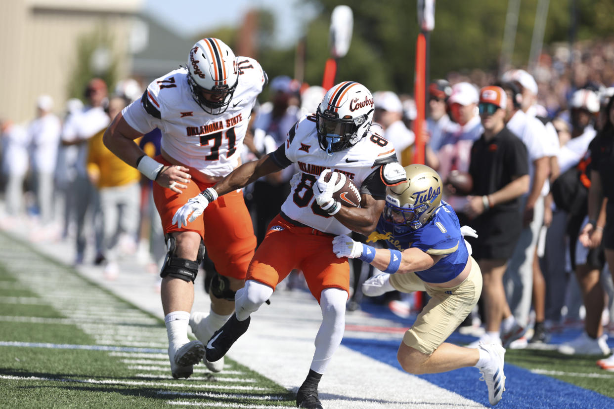 Oklahoma State wide receiver Brennan Presley (80) is tackled by Tulsa safety Dayne Hodge (1) after a reception during the first half of an NCAA college football game, Saturday, Sept. 14, 2024, in Tulsa, Okla. (AP Photo/Joey Johnson)