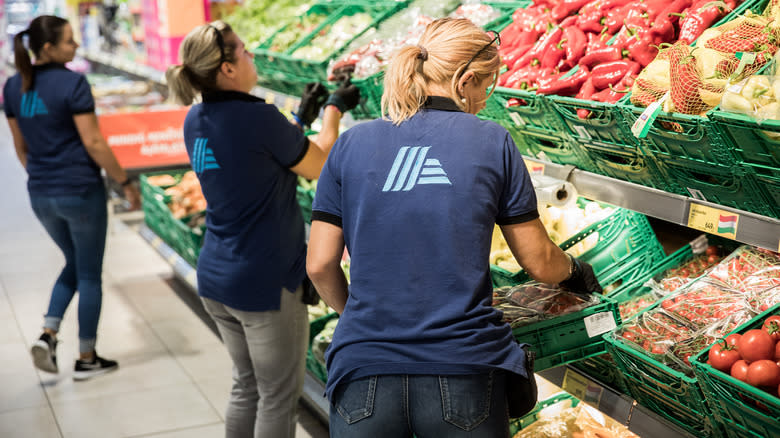 people putting out produce at Aldi