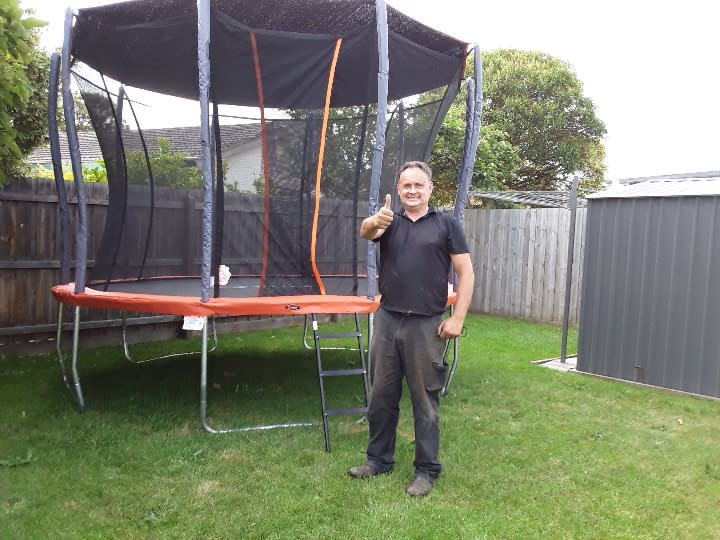 Man looking happy after assembling a trampoline