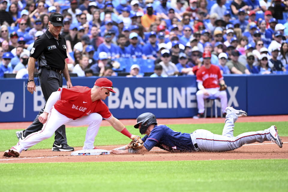 Toronto Blue Jays third baseman Matt Chapman, front left, tags out Minnesota Twins' Jose Miranda, front right, who was attempting to advance on a single by Gilberto Celestino in the first inning of a baseball game in Toronto, Sunday, June 5, 2022. (Jon Blacker/The Canadian Press via AP)