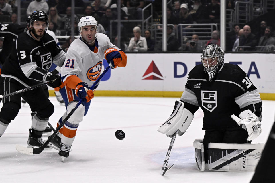 Los Angeles Kings goaltender David Rittich (31) deflects a shot by New York Islanders center Kyle Palmieri (21) with Kings defenseman Matt Roy (3) defending during the first period of an NHL hockey game in Los Angeles, Monday, March 11, 2024. (AP Photo/Alex Gallardo)