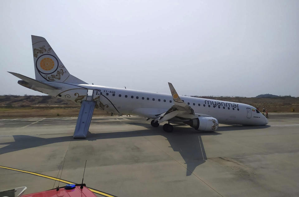 A Myanmar National Airlines plane sits on the runway at Mandalay International airport on Sunday after its pilot was forced to land the aircraft without its front wheels deploying, (Photo: ASSOCIATED PRESS)