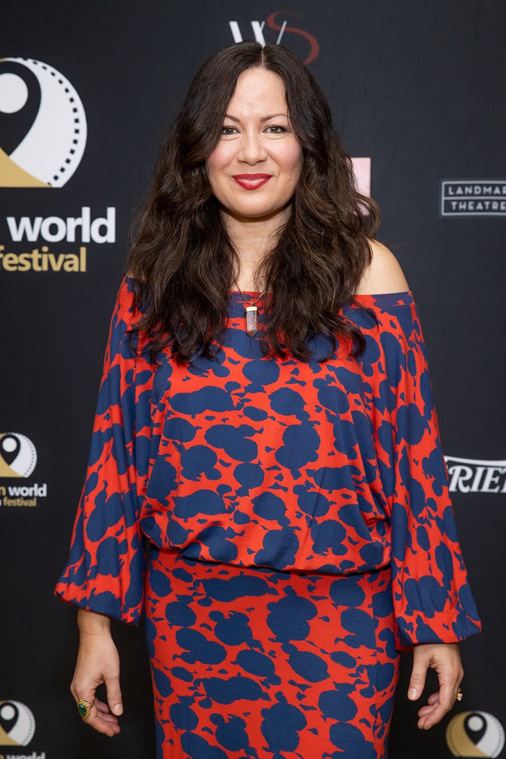 Shannon Lee wearing a blue and orange dress