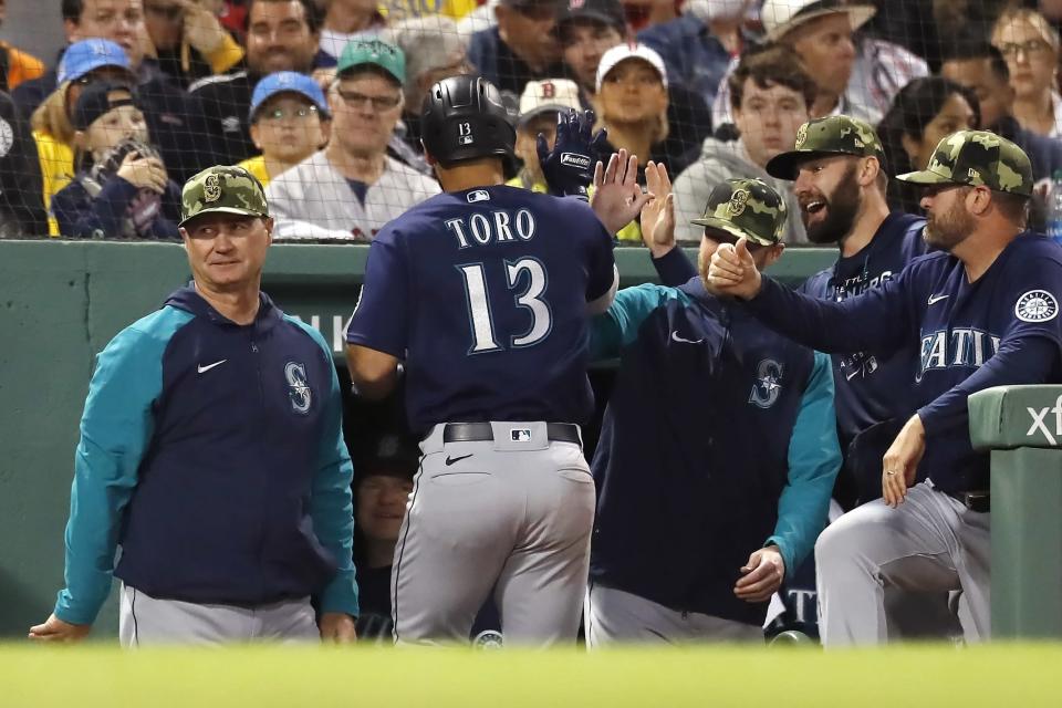 Seattle Mariners' Abraham Toro (13) is congratulated for his two-run home run during the fifth inning of the team's baseball game against the Boston Red Sox, Friday, May 20, 2022, in Boston. (AP Photo/Michael Dwyer)