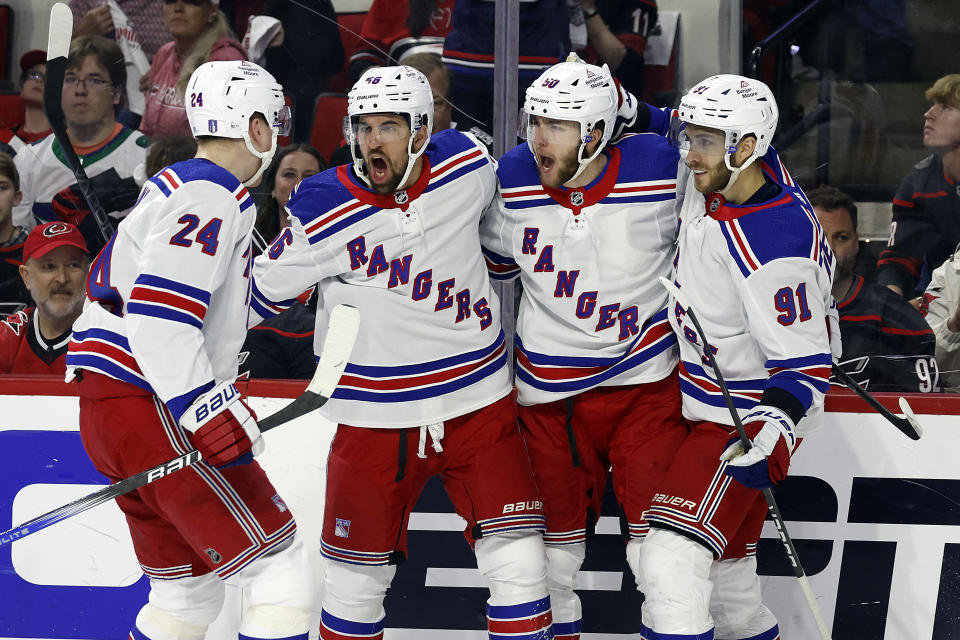 New York Rangers congratulate Will Cuylle, second from right, during the first period in Game 4 of an NHL hockey Stanley Cup second-round playoff series against the Carolina Hurricanes in Raleigh, N.C., Saturday, May 11, 2024. (AP Photo/Karl B DeBlaker)