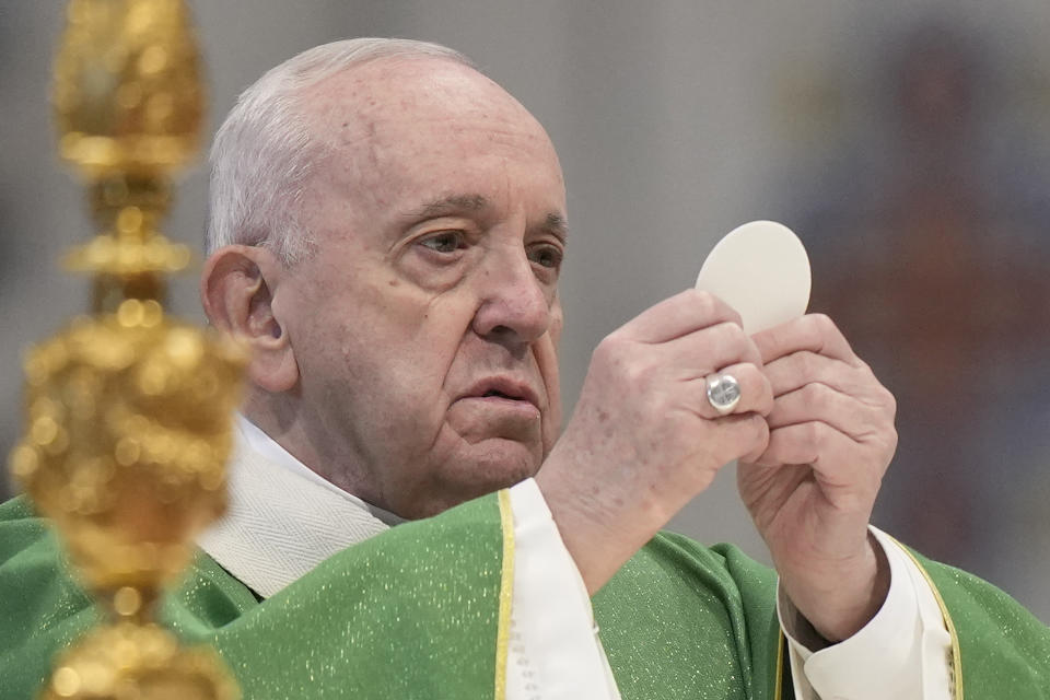 Pope Francis holds the sacred host as he celebrates mass to mark the day of the Word of God, in St.Peter's Basilica, at the Vatican, Sunday, Jan. 23, 2022. (AP Photo/Andrew Medichini)