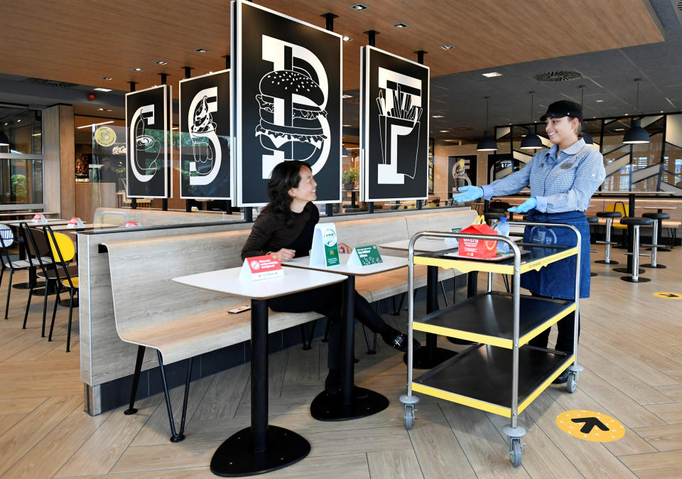 A customer receives her order inside a prototype location of fast food giant McDonald's for restaurants which respect the 1.5m social distancing measure, amid the coronavirus disease (COVID-19) outbreak, in Arnhem, Netherlands, May 1, 2020. REUTERS/Piroschka van de Wouw