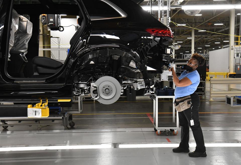 Assembly line workers at the Mercedes-Benz U.S. International factory in Tuscaloosa County add parts to an electric vehicle on Aug. 25, 2022.