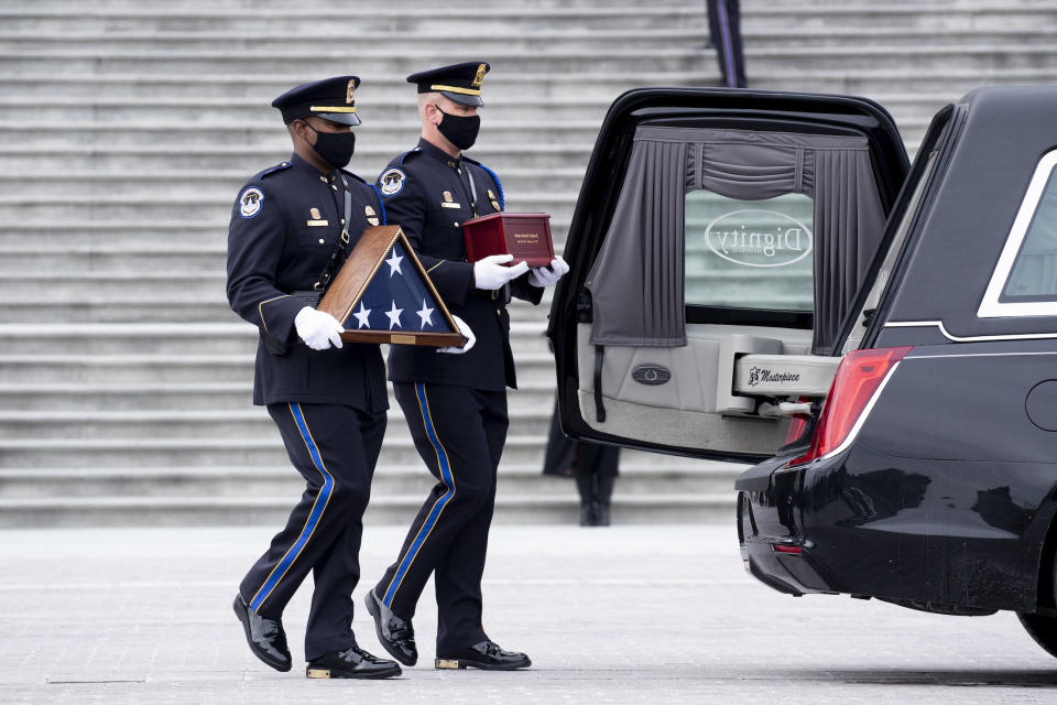 An honor guard carries an urn with the cremated remains of officer Brian Sicknick to a hearse at the Capitol on Feb. 3, 2021.