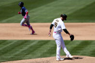 Tampa Bay Rays' Mike Brosseau, left, rounds the bases after hitting a solo home run against the Oakland Athletics' Cole Irvin, right, during the sixth inning of a baseball game in Oakland, Calif., Sunday, May 9, 2021. (AP Photo/Jed Jacobsohn)