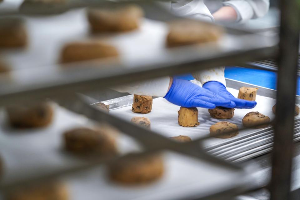 Jacob Rich works on cutting cookie dough and shaping cookies to be baked at D'VINE Cookies in Taylor on January 4, 2023.