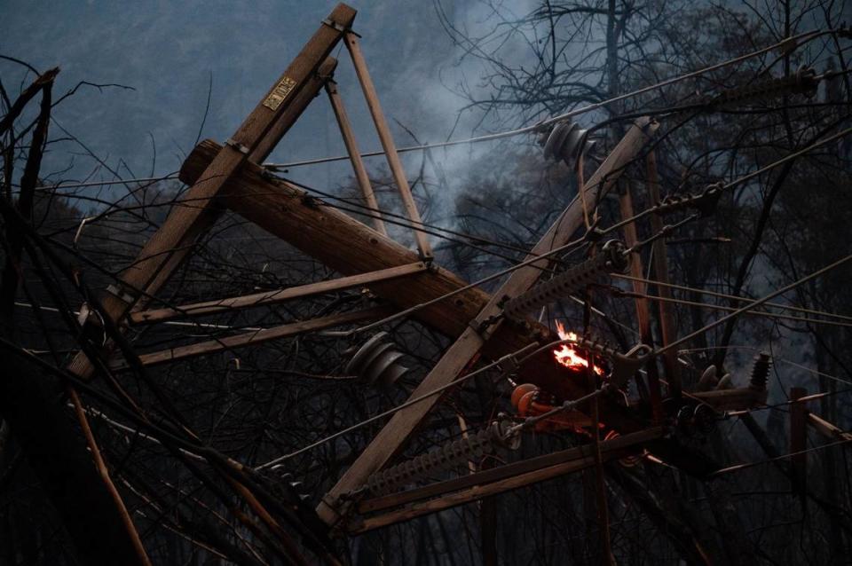 Fallen electrical wires smolder and flare up as the Dixie Fire passes through Plumas County on Wednesday, July 21, 2021. State and federal lawmakers are proposing legislation to help address the wildfires raging across much of the American West.