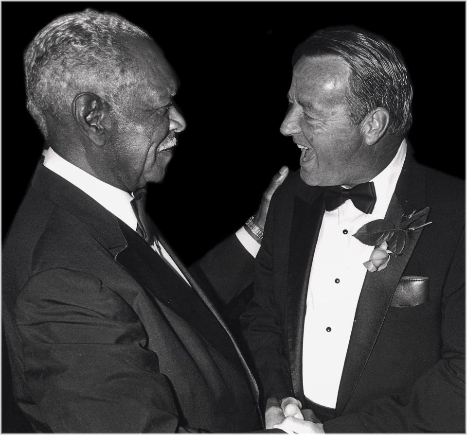 College Football Hall of Famers Jake Gaither of FAMU (left) and Bobby Bowden share a laugh at a banquet.