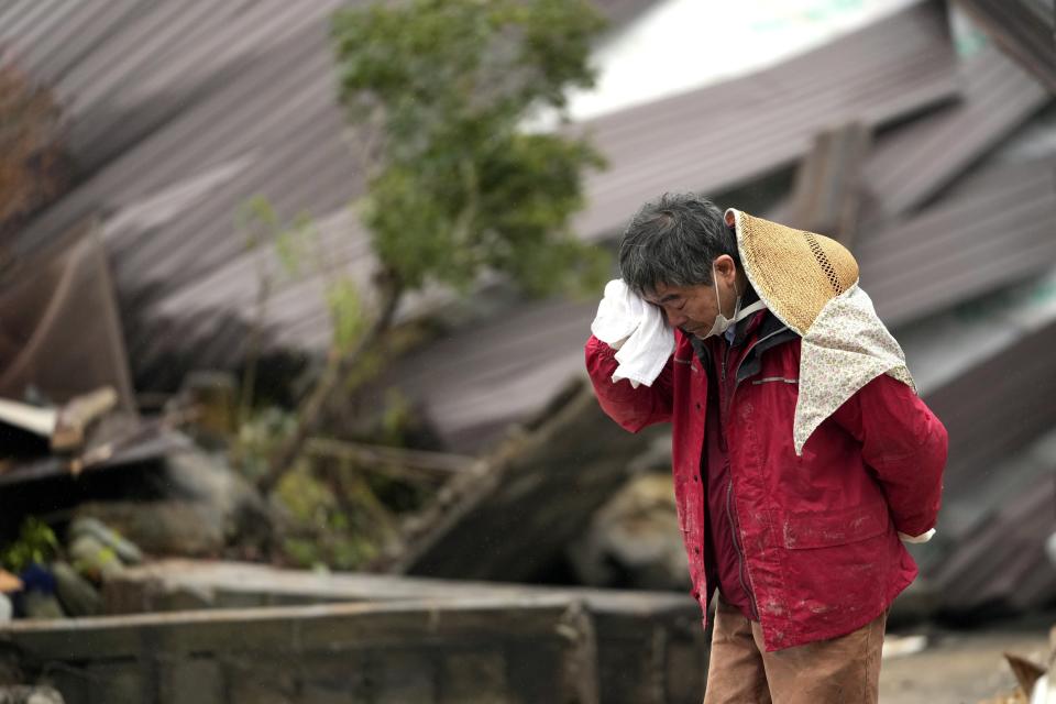 A man cries as a body of his family member was found from a collapsed house caused by powerful earthquake in Suzu, Ishikawa Prefecture Wednesday, Jan. 3, 2024. (AP Photo/Hiro Komae)