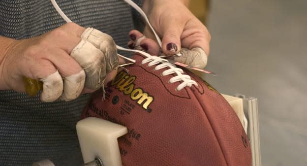 Workers manufacture footballs at Wilson Sports factory