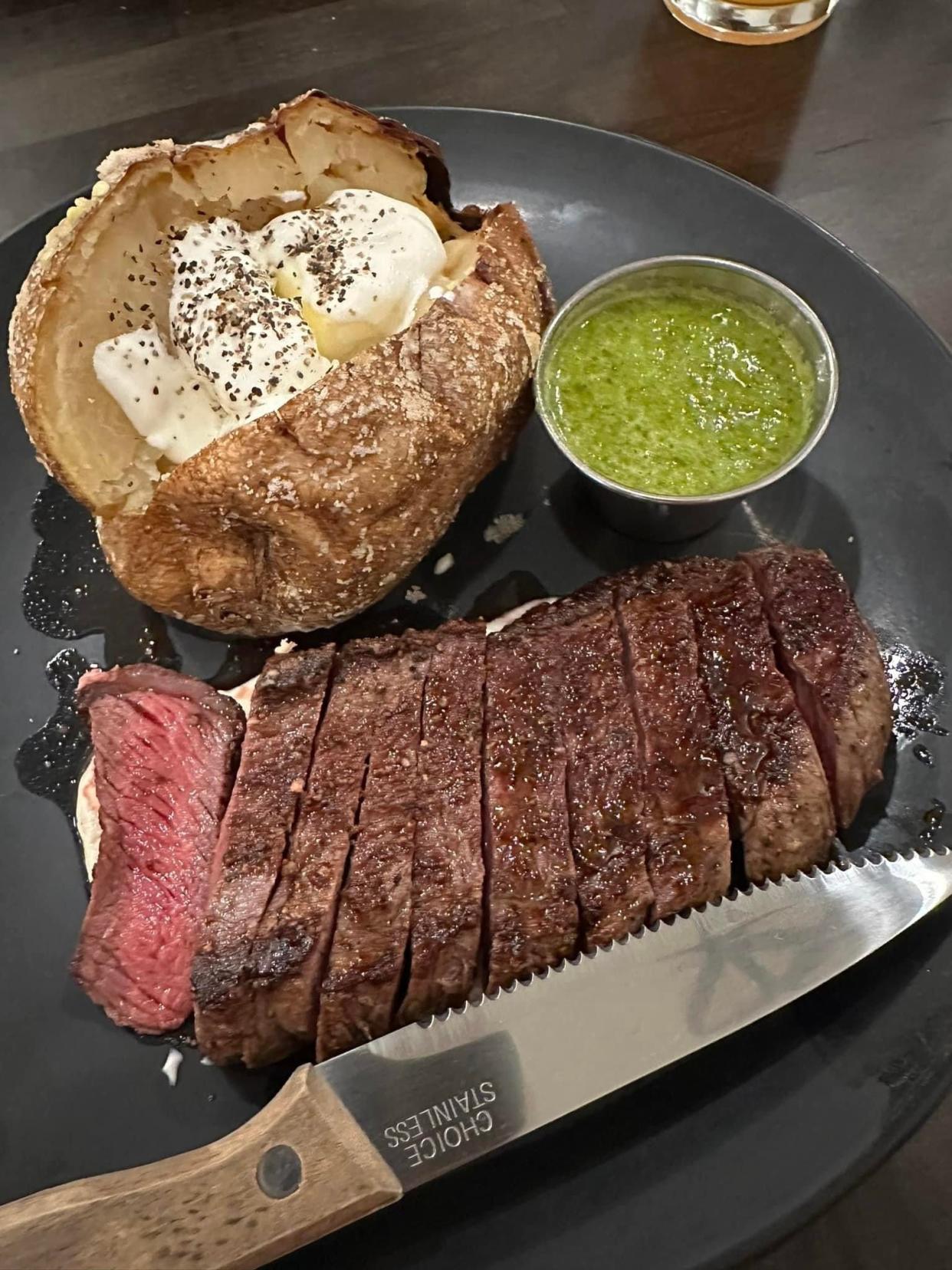 A coulotte steak served over horseradish cream with herb-based salsa verde and a salt baked potato at Cap & Cork in Henderson, Ky.