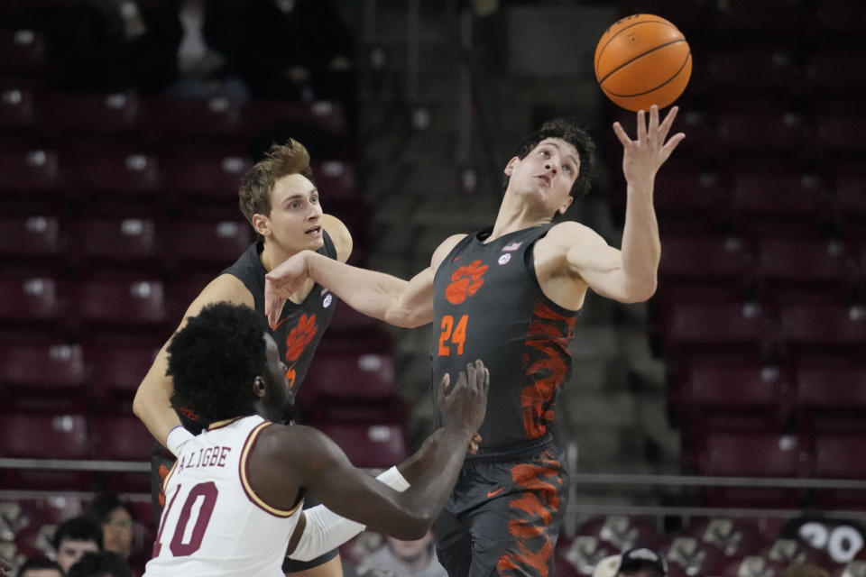 Clemson center PJ Hall (24) grabs a rebound against Boston College guard Prince Aligbe (10) during the first half of an NCAA college basketball game, Tuesday, Jan. 31, 2023, in Boston. (AP Photo/Charles Krupa)