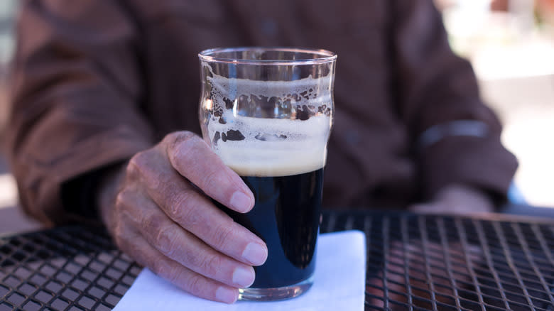 Hand on stout glass