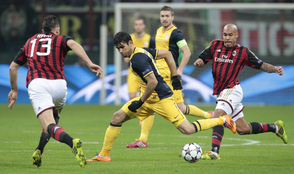 Atletico Madrid Brazilian forward Diego Costa, center, struggles with the ball between AC Milan midfielder Nigel De Jong of The Netherlands, right, and Adil Rami of France, during a round of 16th Champions League soccer match between AC Milan and Atletico Madrid at the San Siro stadium in Milan, Italy, Wednesday, Feb. 19, 2014. (AP Photo/Emilio Andreoli)