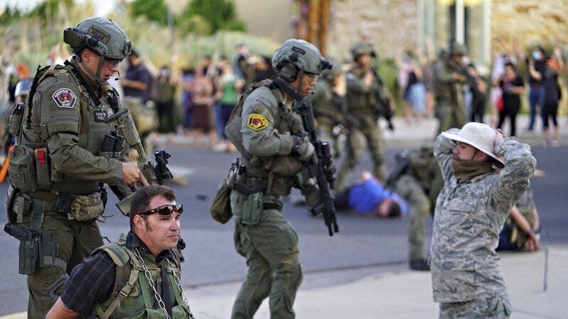Albuquerque police detain members of the New Mexico Civil Guard, an armed civilian group, following the shooting of a man during a protest over a statue of Spanish colonial official Juan de O&ntilde;ate on Monday. (Photo: Adolphe Pierre-Louis/The Albuquerque Journal via Associated Press)