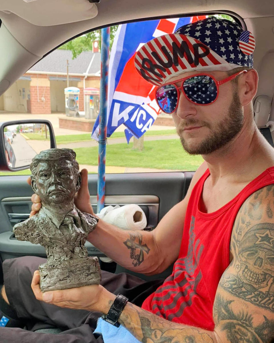 Lance Ligocki holds a statue while sitting in a car. (U.S. District Court)