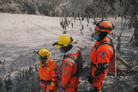 Members of the Guatemala's National Disaster Management Agency (CONRED) survey an area affected by the eruption of the Fuego volcano at El Rodeo in Escuintla, Guatemala June 5, 2018. REUTERS/Jose Cabezas