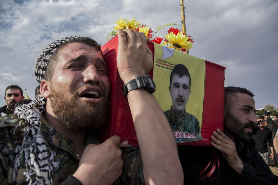 People attend funerls of Syrian Democratic Forces fighters killed recently fighting Turkish forces in the town of Hasakeh, north Syria, Monday, Oct. 21, 2019. (AP Photo/Baderkhan Ahmad)