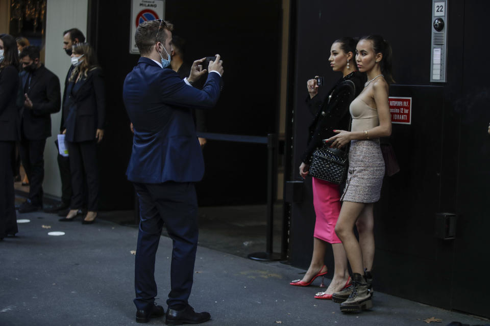 Two guests pose prior to the Dolce & Gabbana 2021 women's spring-summer ready-to-wear collection during the Milan's fashion week in Milan, Italy, Wednesday, Sept. 23, 2020. (AP Photo/Luca Bruno)