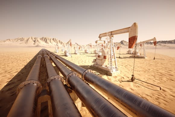 A series of pipes and oil pumps in a desert landscape