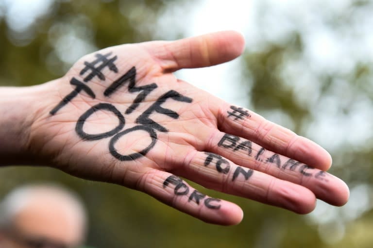 A picture shows the messages #Me too and #Balancetonporc (Squeal on your pig) on the hand of a protester in Paris