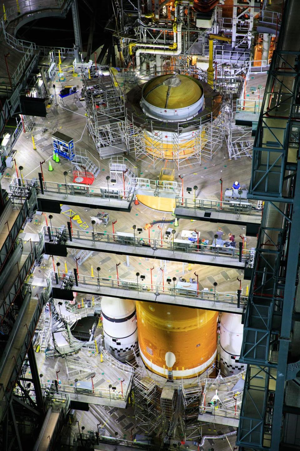 space launch system orange rocket core in construction facility with tiered platforms