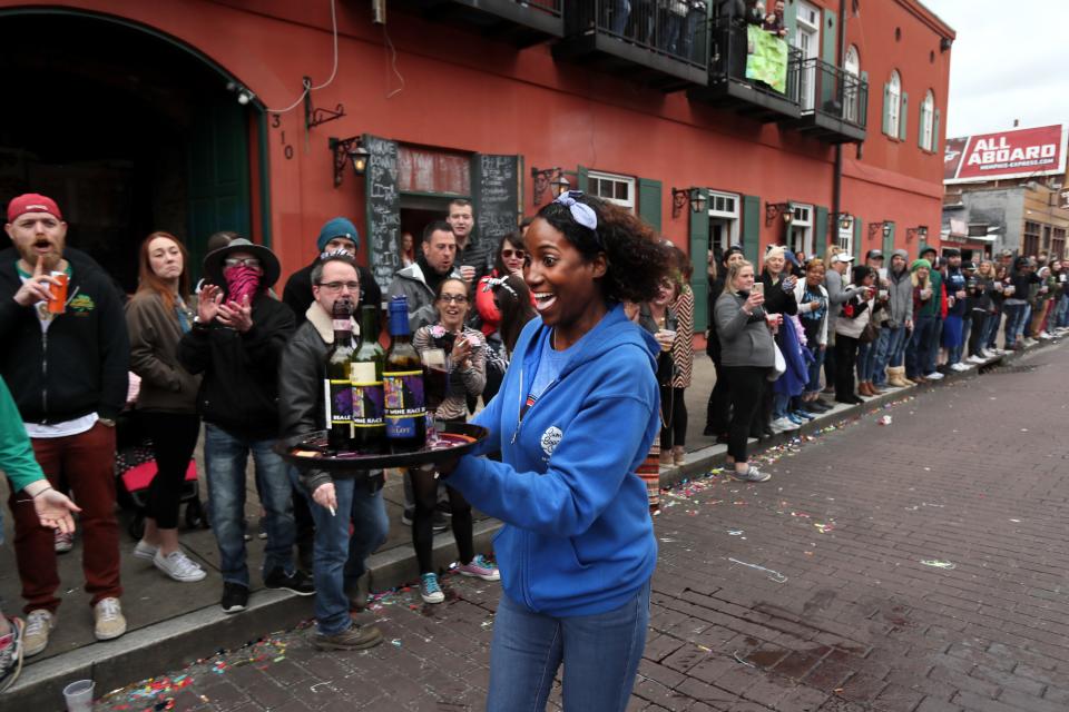 Takena Walton speeds down the street with a tray full of bottles and glassware during the Beale Street Wine Race downtown on Sunday, April 14, 2019.
