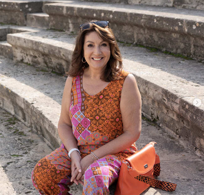 Jane McDonald sat on stone steps