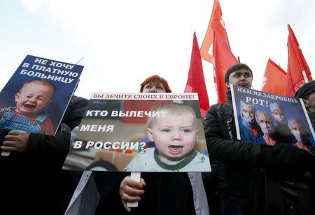 Activists hold posters during a protest in support of Russian doctors and patients titled "Stop the collapse of Moscow's medicine!", against reforms to the healthcare system in Moscow in this November 2, 2014 file photo. REUTERS/Sergei Karpukhin/Files