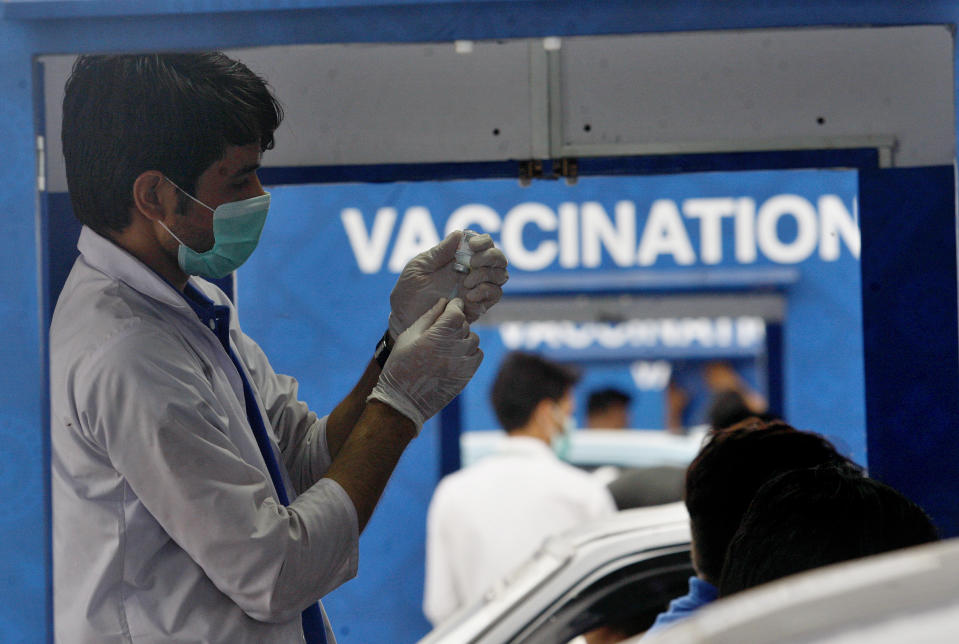 A health worker prepare the Sinovac COVID-19 vaccine at a drive-through vaccination center, in Karachi, Pakistan, Saturday, July 31, 2021. (AP Photo/Fareed Khan)